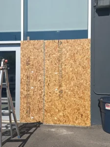 Two OSB sheets securing a large commercial storefront window